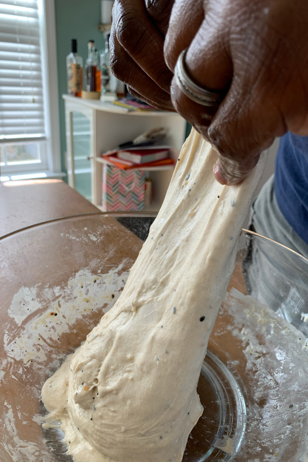 man stretching sourdough dough